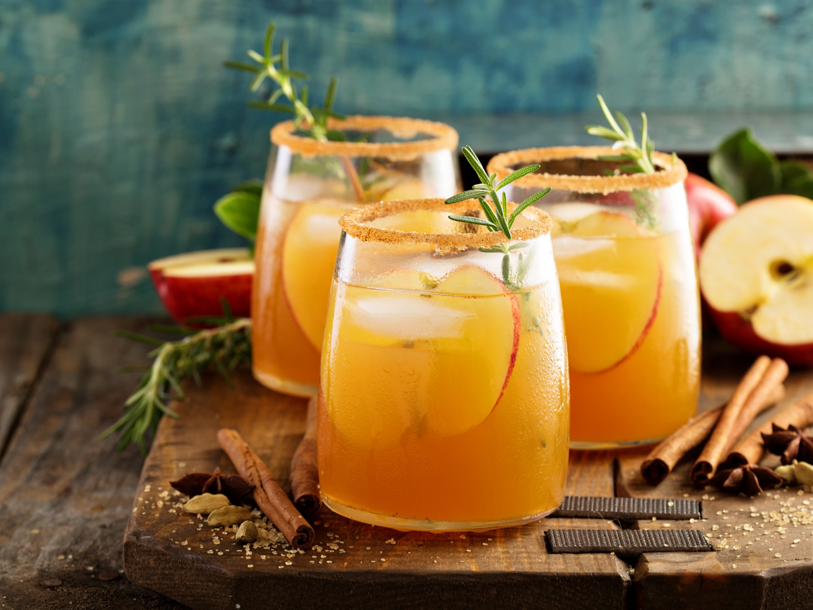 apple cider sangria with sprigs of rosemary and apple slices in glasses