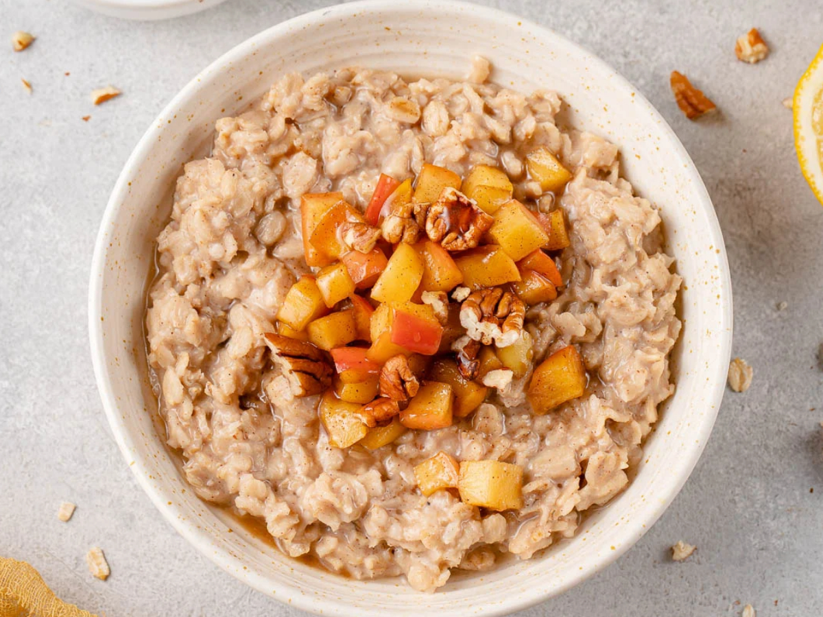 bowl of apple cinnamon oatmeal with fruit and nuts