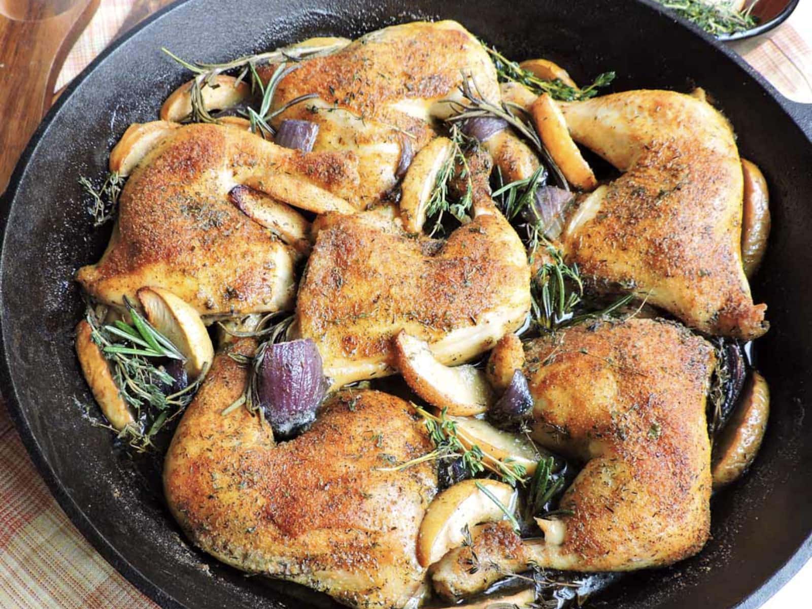 apple roasted chicken in a skillet with veggies