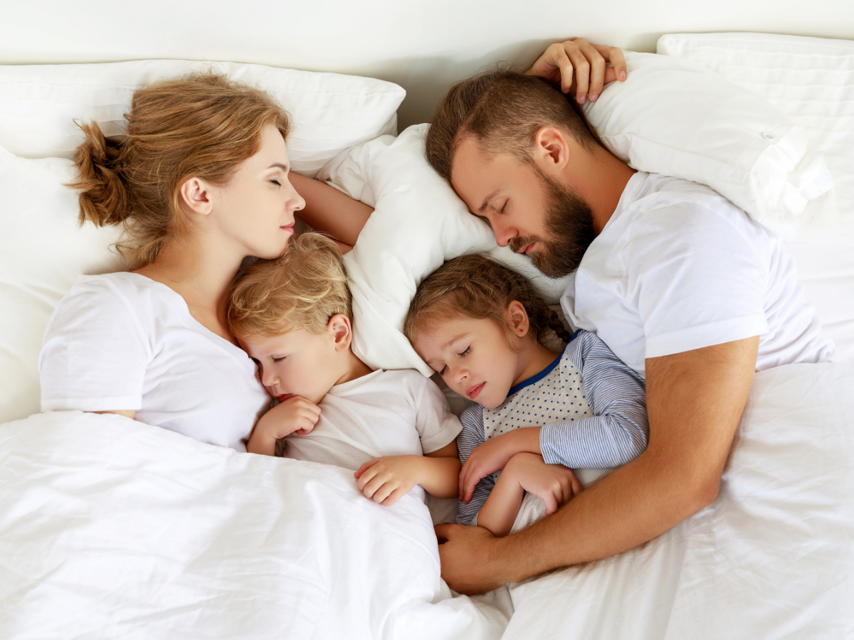 family sleeping in bed
