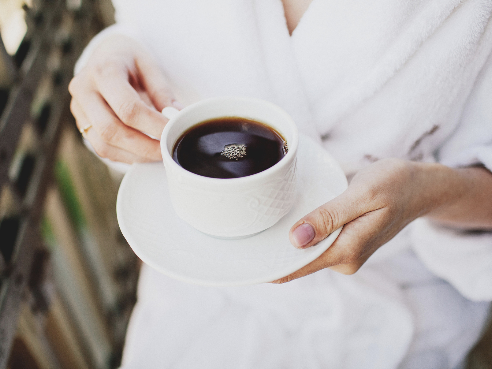 person drinking coffee in the morning wearing a robe