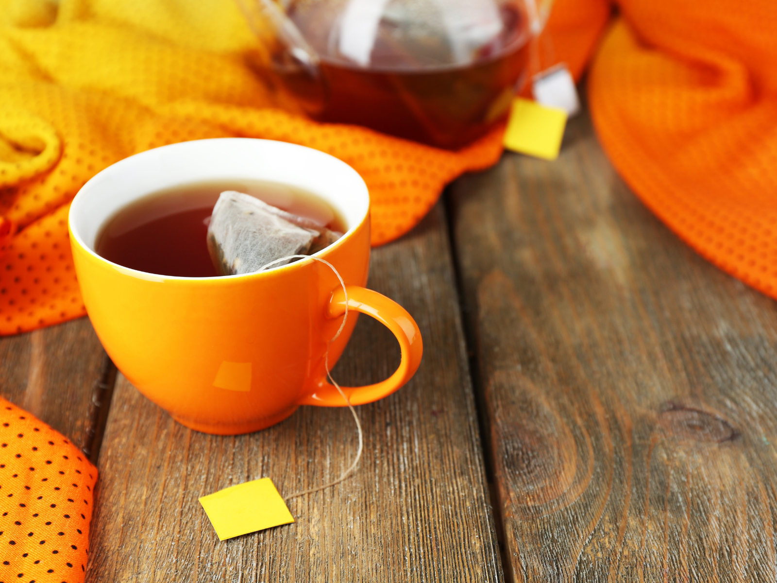 cup of black tea with a teapot and tea bags