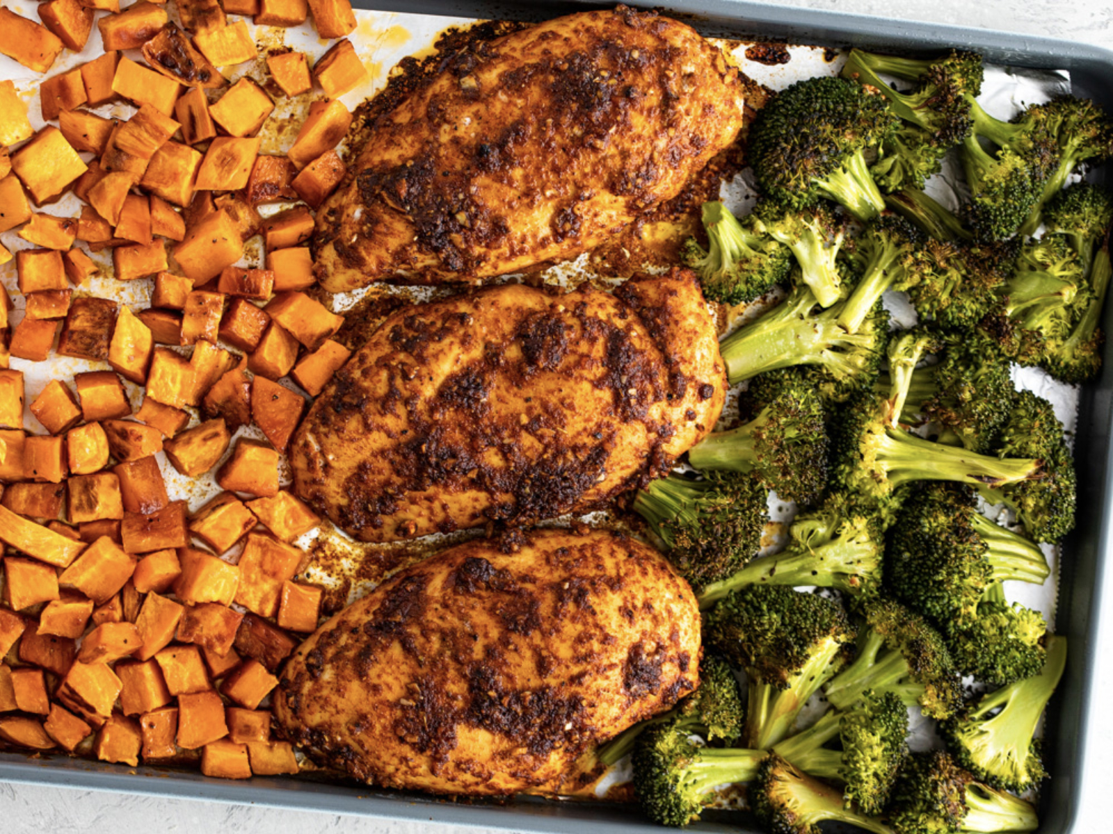 healthy sheet pan dinner with chicken sweet potato and roasted broccoli
