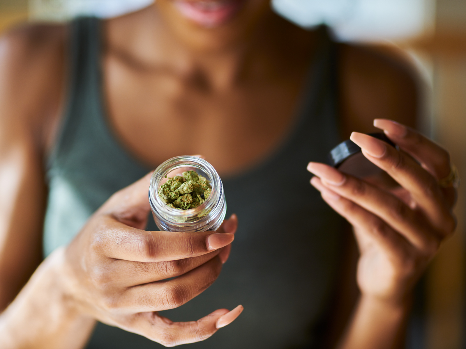 woman holding open container of cannabis