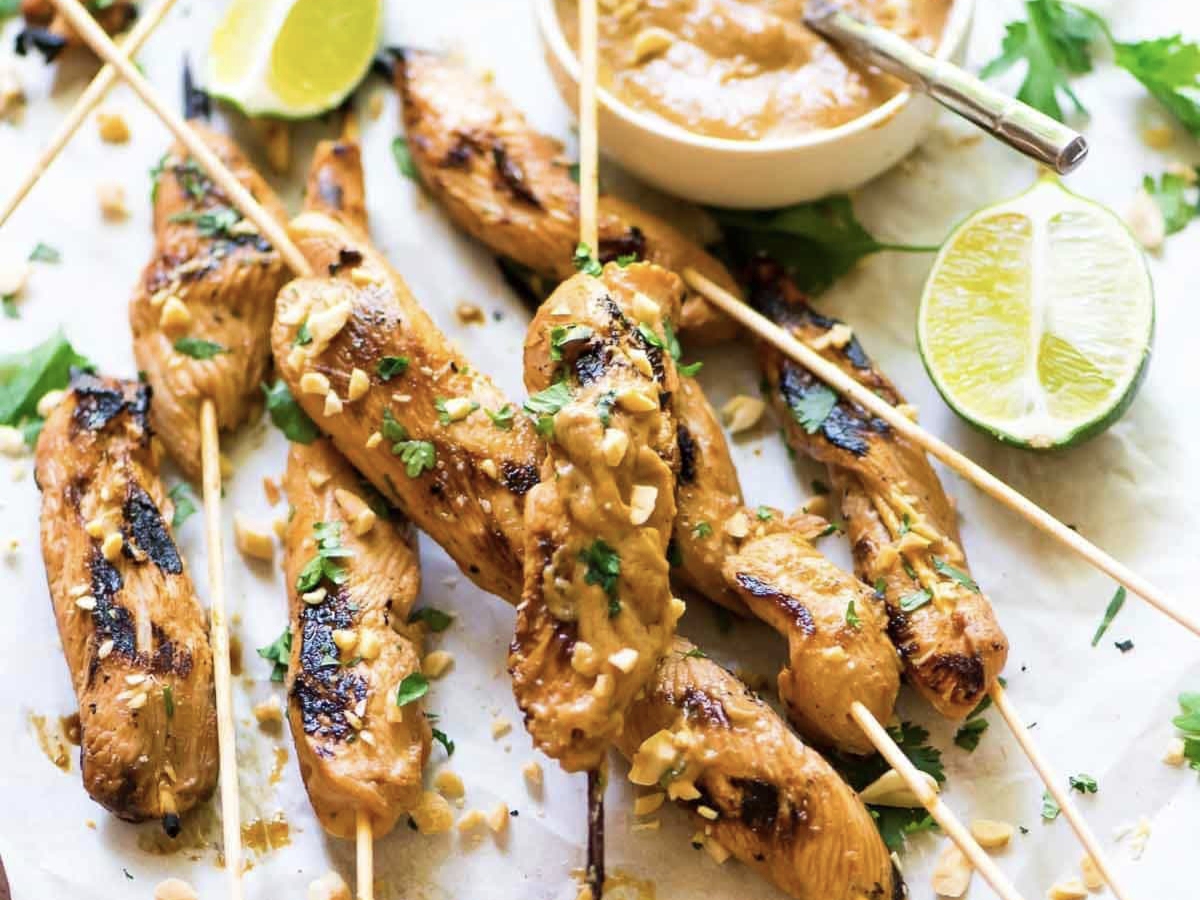 chicken satay with homemade peanut sauce and limes