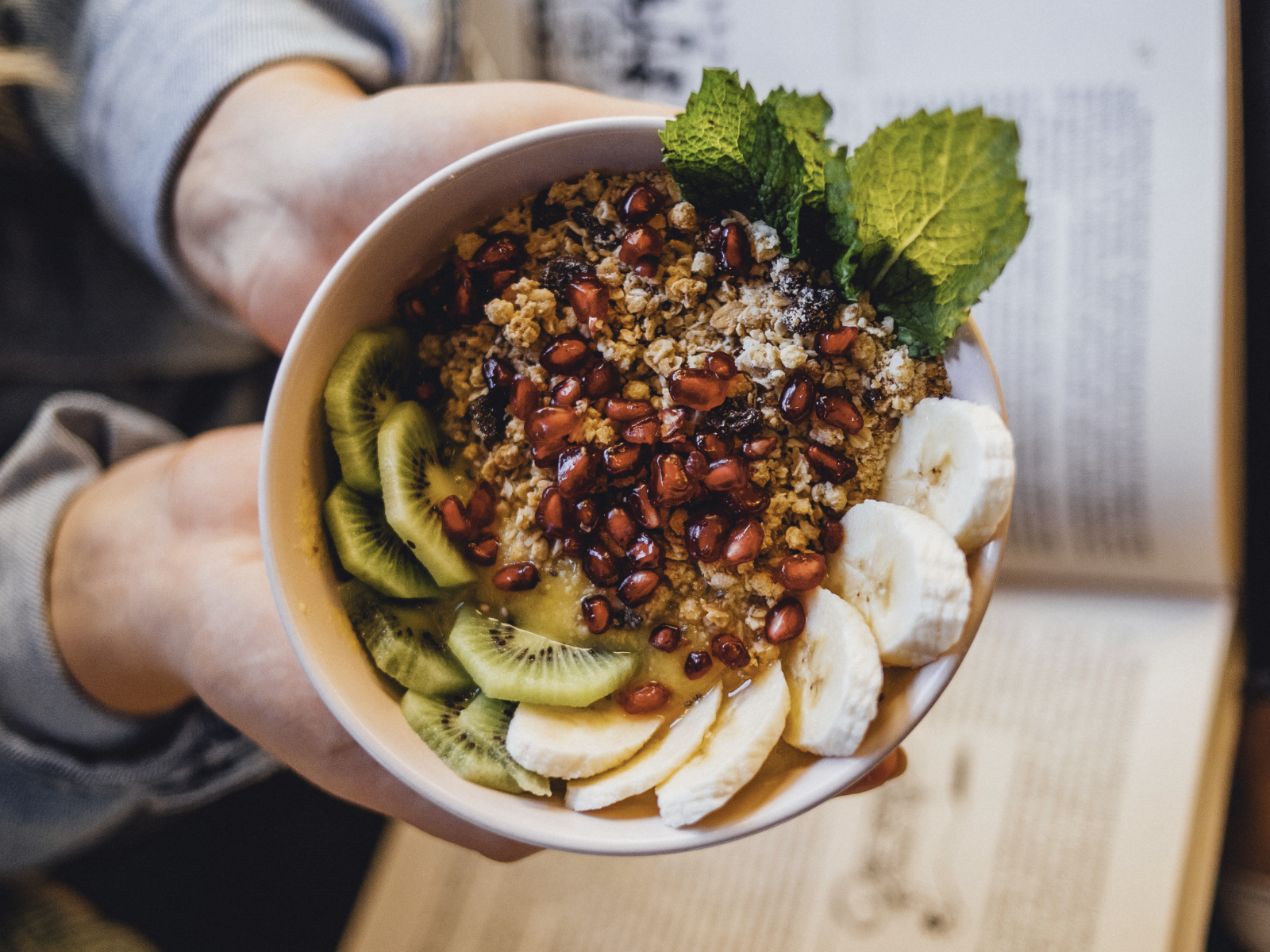 woman holding a breakfast bowl of plant based foods