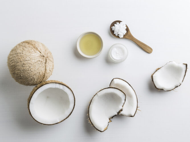 cracked open coconut and coconut oil in bowls