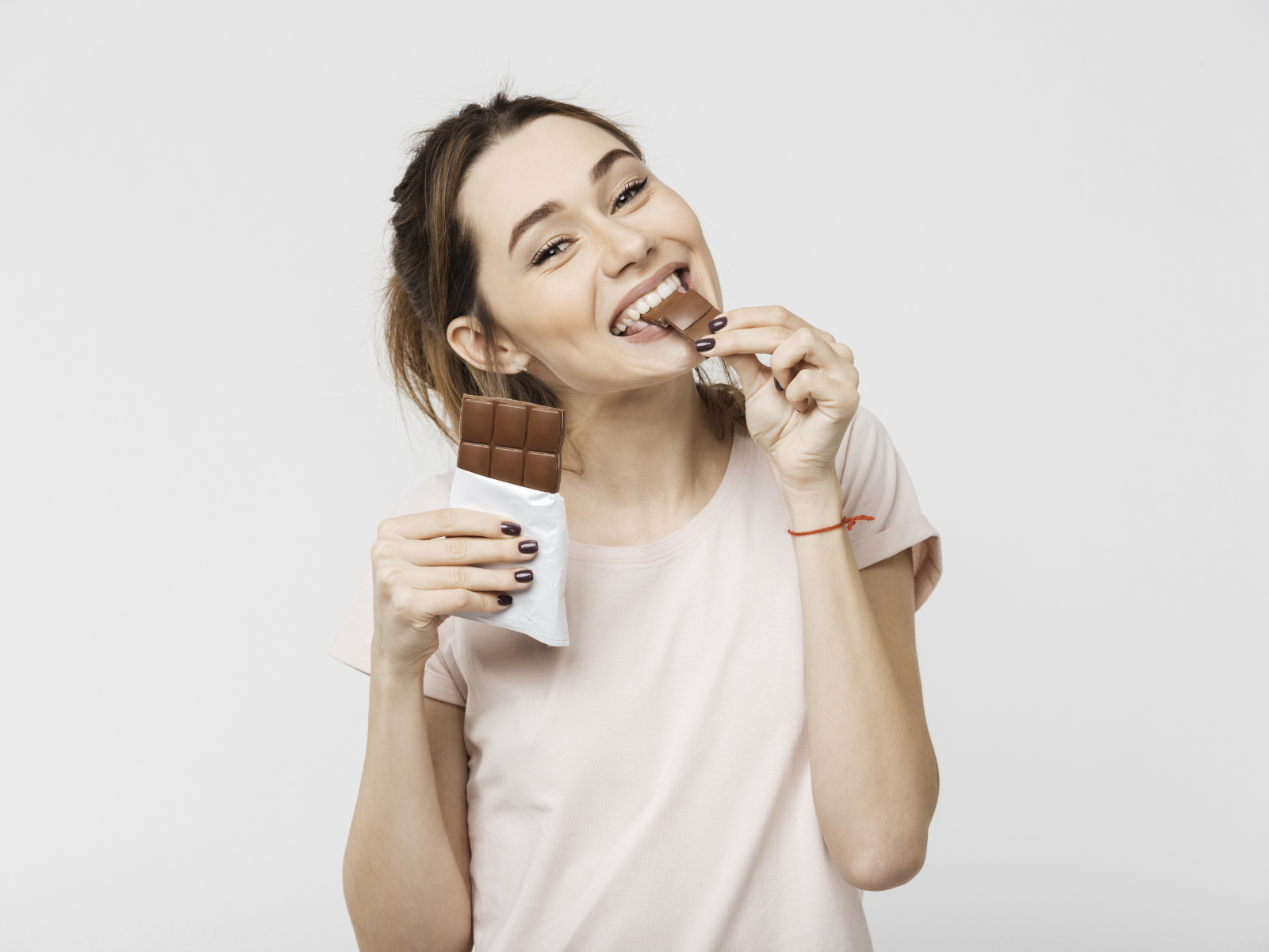 woman biting into a chocolate bar