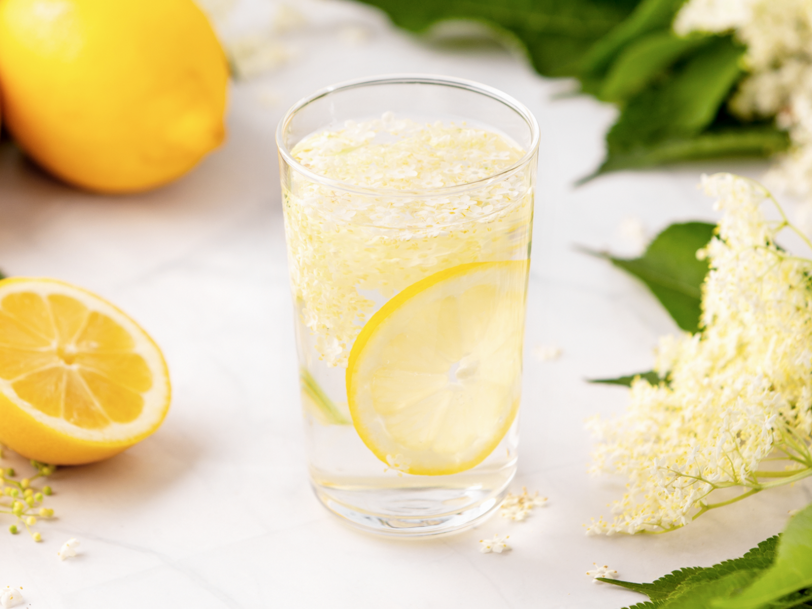 elderflower lemon drink in a high ball glass