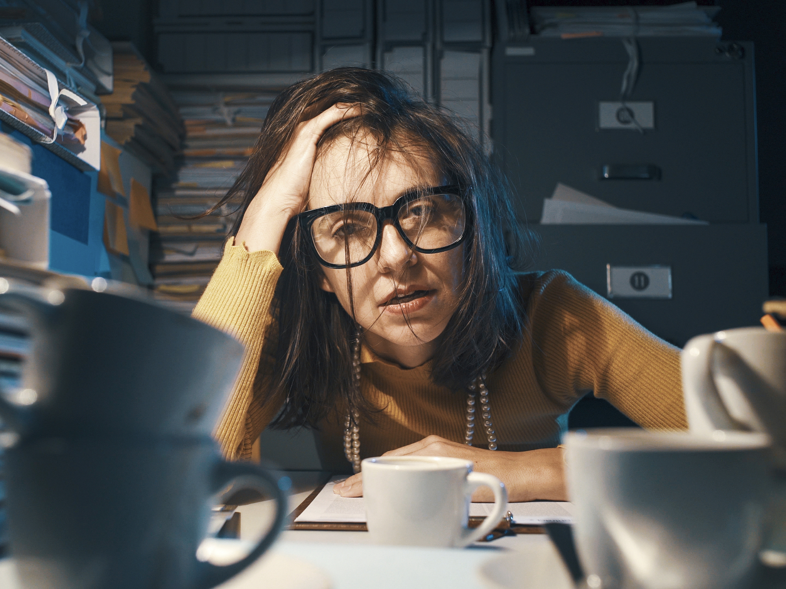 woman looking exhausted at her desk