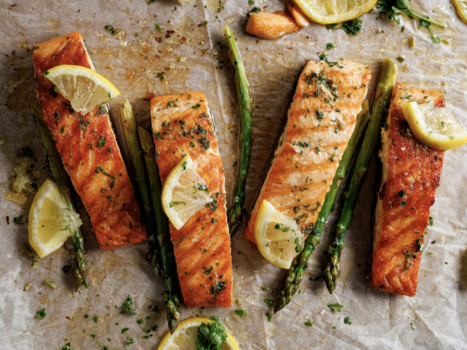 salmon fillets with lemon wedges and asparagus