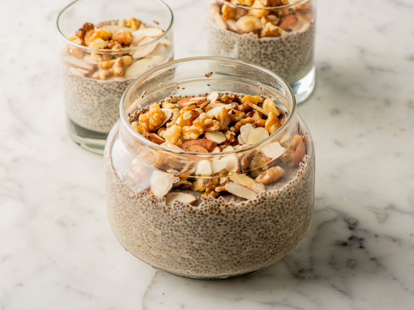 chia seed pudding jars topped with nuts and seeds