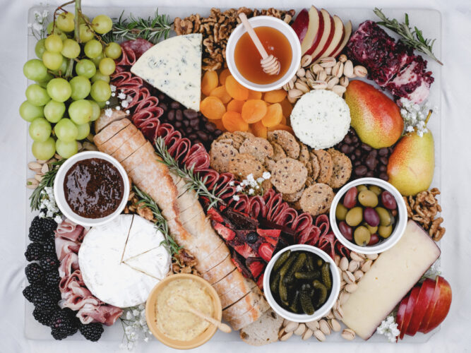 grazing board with cheese, meats, fruits, spreads, and crackers