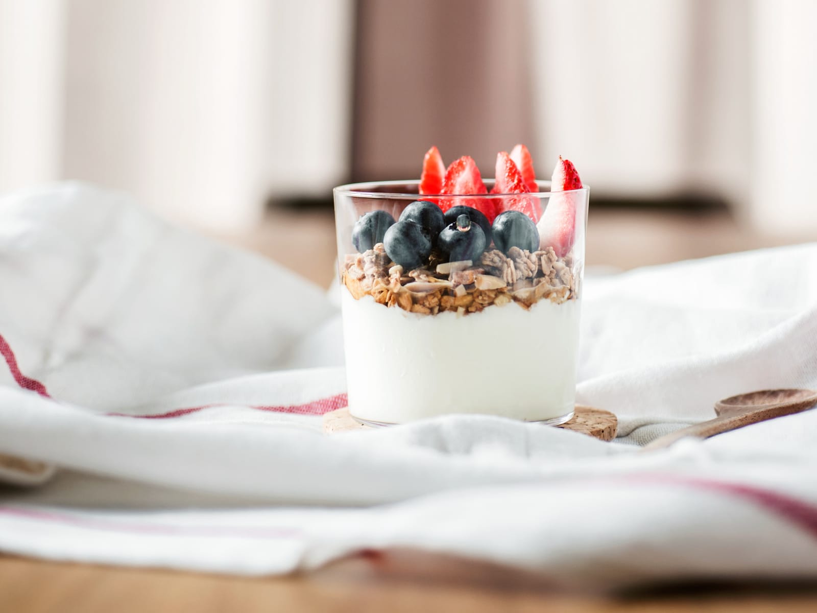 cup of greek yogurt with berries and granola in the morning