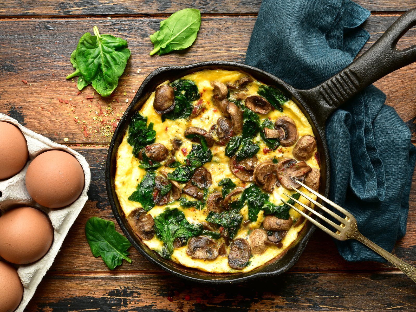 Scrambled eggs with spinach and mushrooms in a skillet