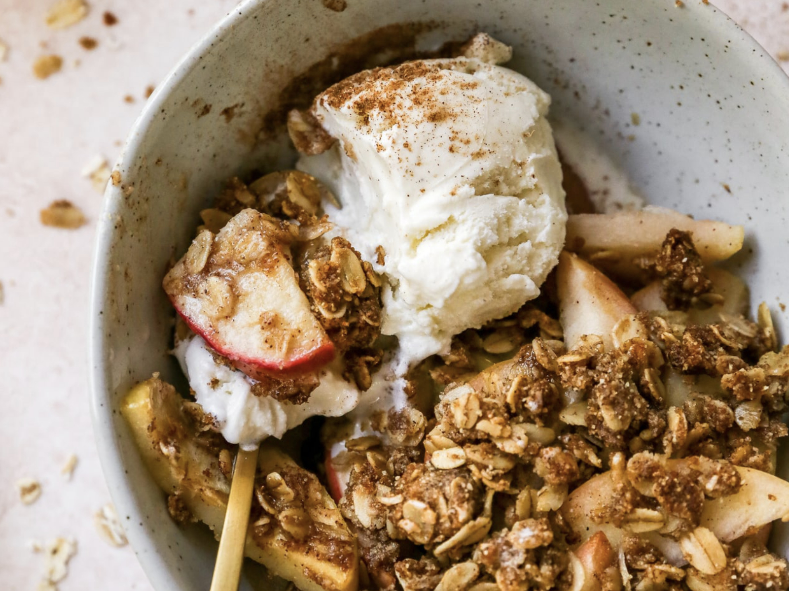 healthy apple crisp in a bowl with vanilla ice cream