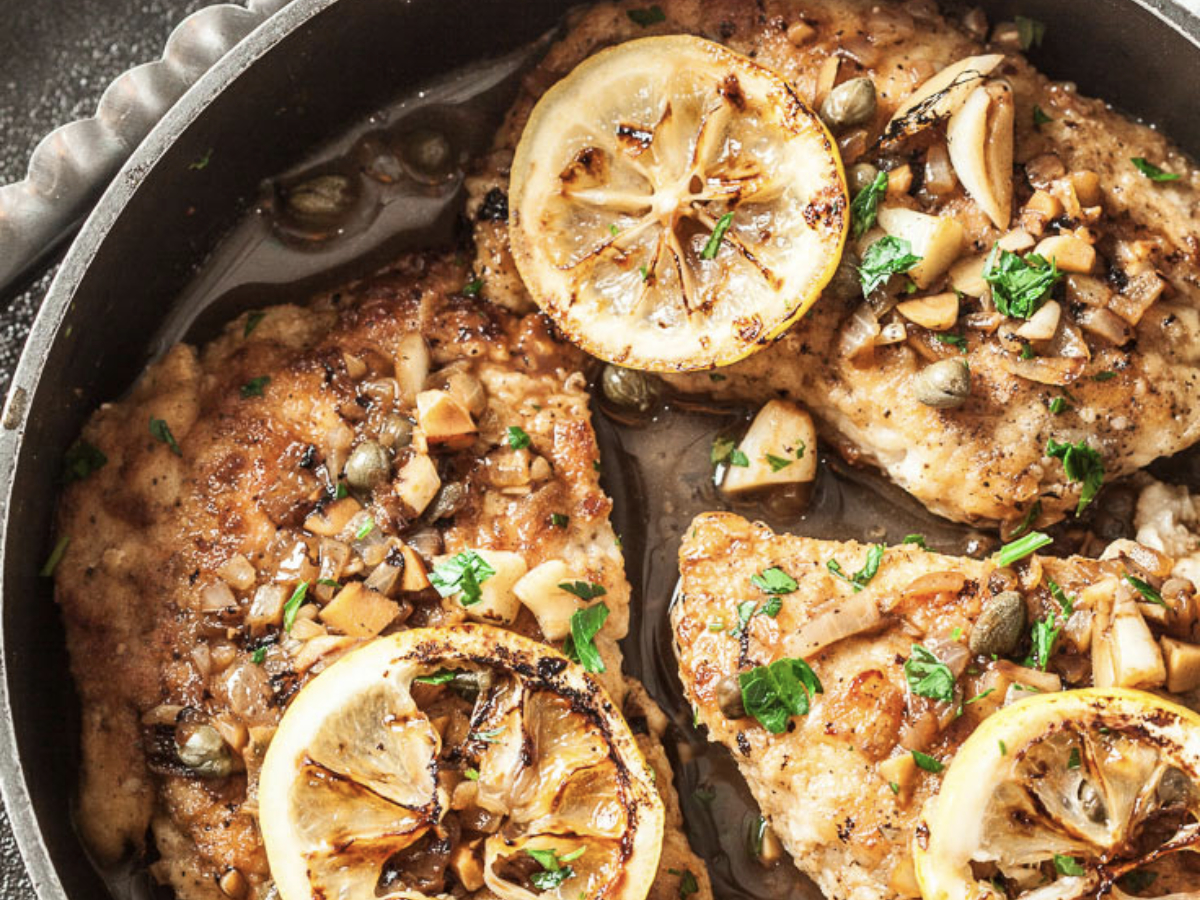 chicken piccata in a skillet with lemon slices