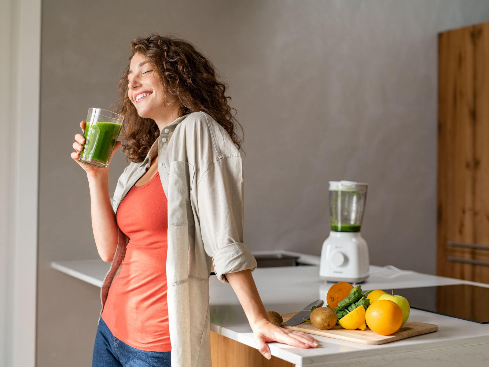 healthy woman drinking a green smoothie