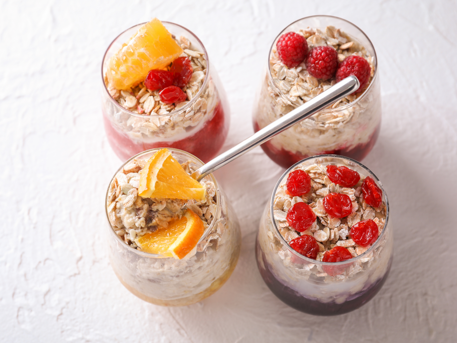overnight oats with citrus fruits and raspberries in cups