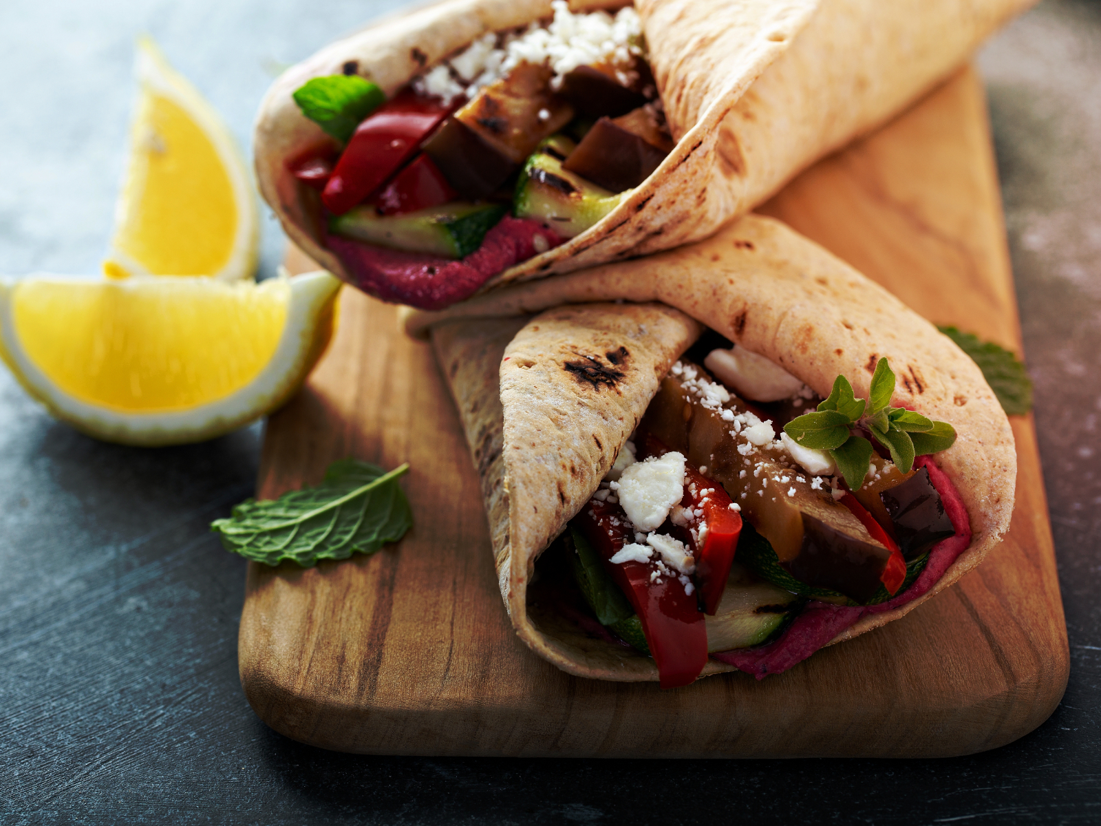 Whole grain wrap with hummus, grilled vegetables, and feta cheese