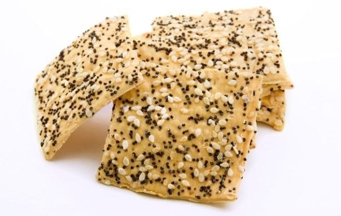 Gourmet sesame seed crackers against a white background.