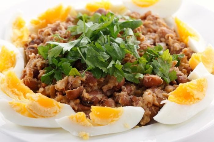 Egyptian foul - or ful - medames on a plate garneshed with slices of hard-boiled egg and flat-leaf parsley