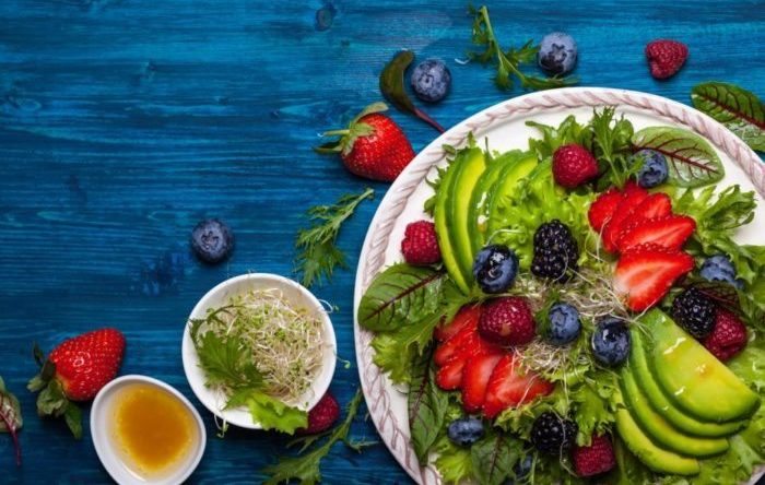Mixed salad leaves with berries, avocado and honey-mustard dressing