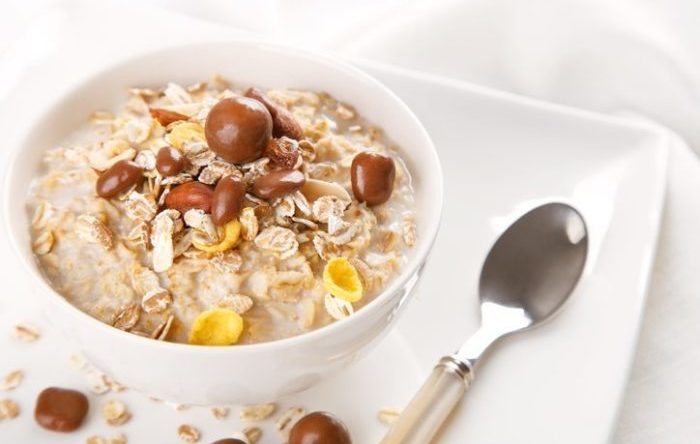 Healthy and natural breakfast, oatmeal and chocolate dragees in a bowl
