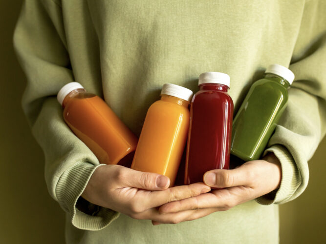 person holding juice bottles for a cleanse