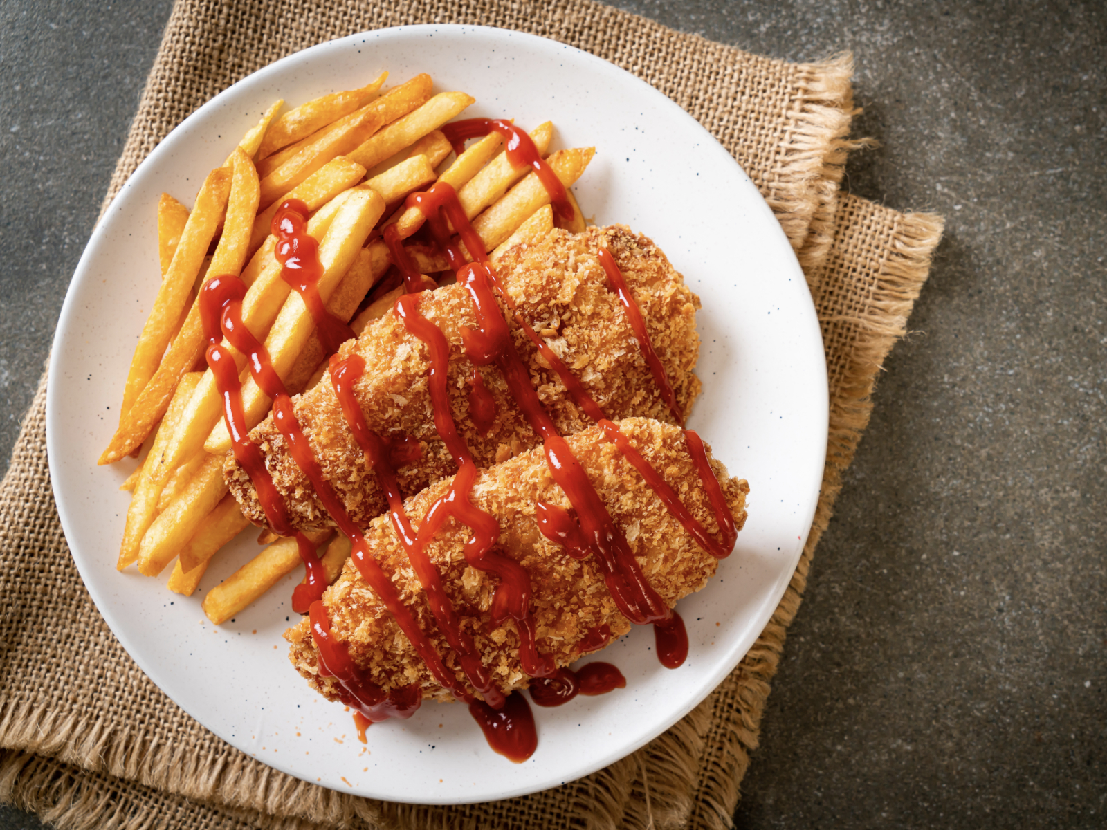 ketchup drizzled on fried chicken and french fries