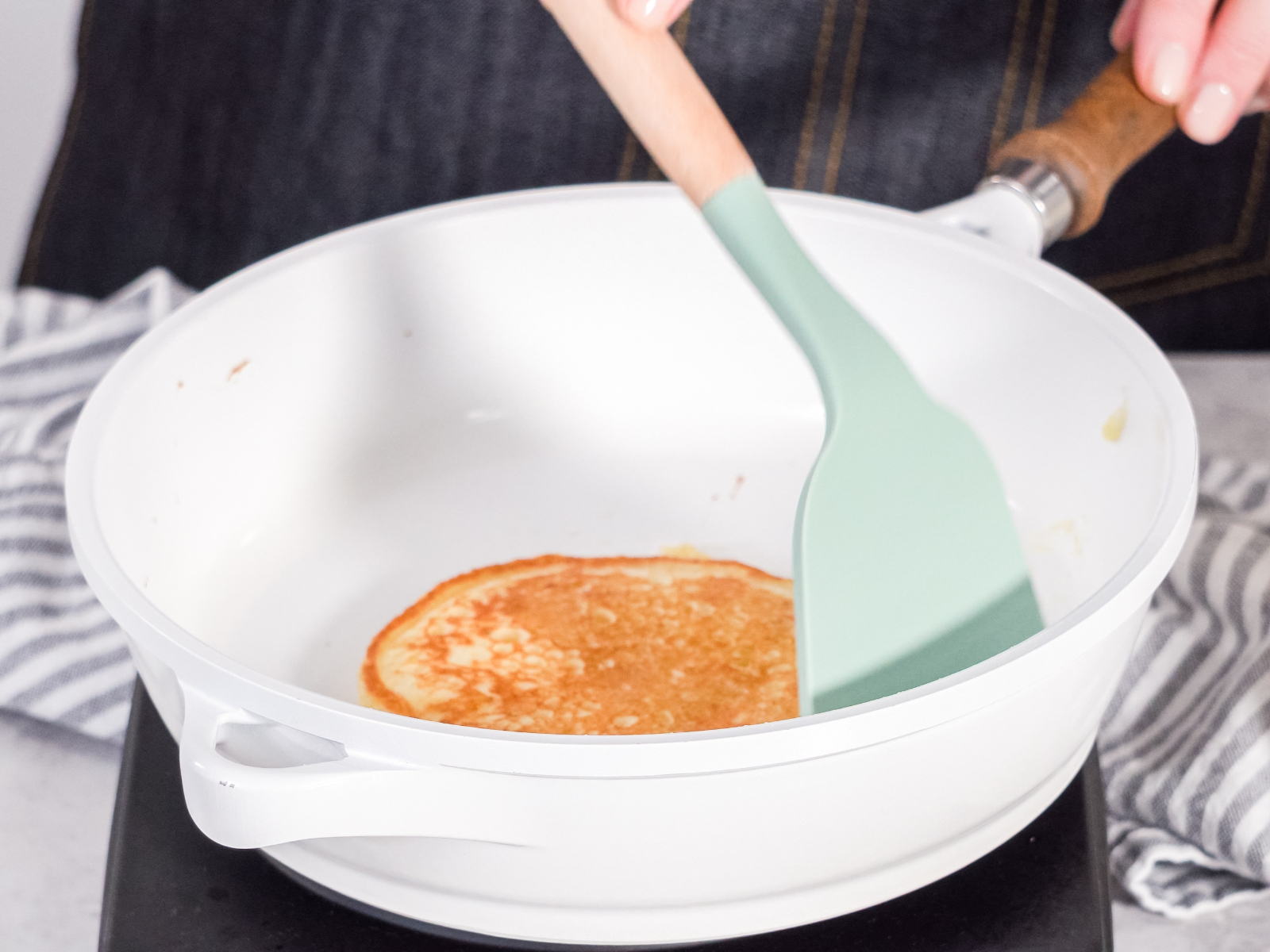 person flipping a pancake in a pan in the morning