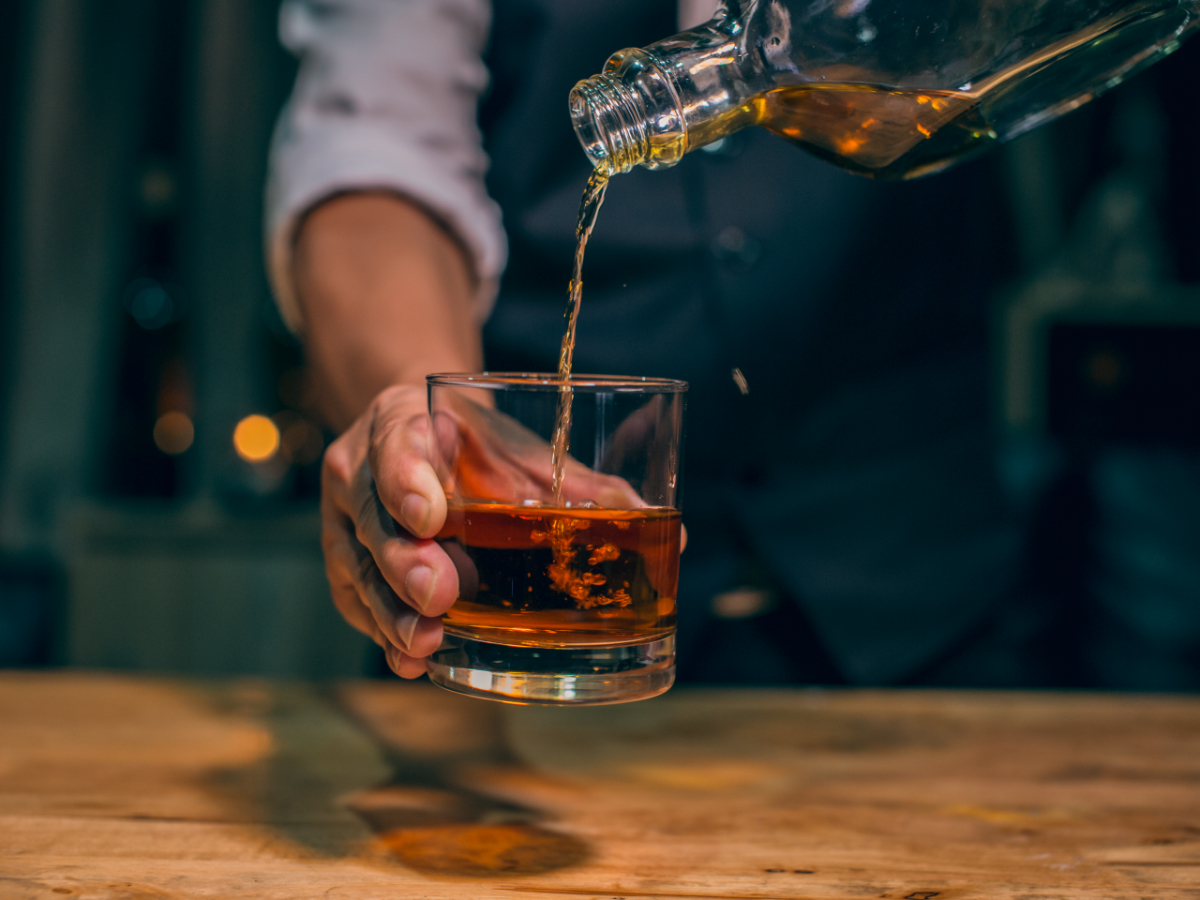 man pouring a glass of whiskey