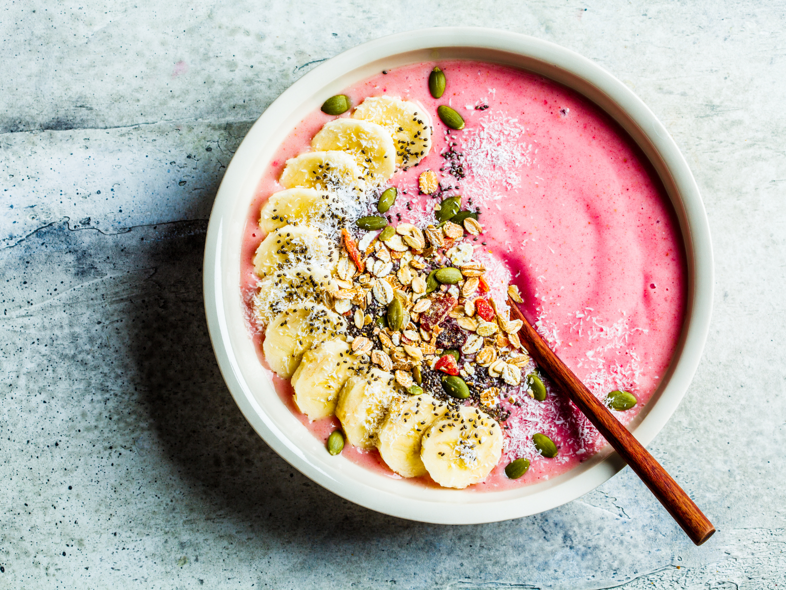 berry smoothie bowl with sliced banana and seeds