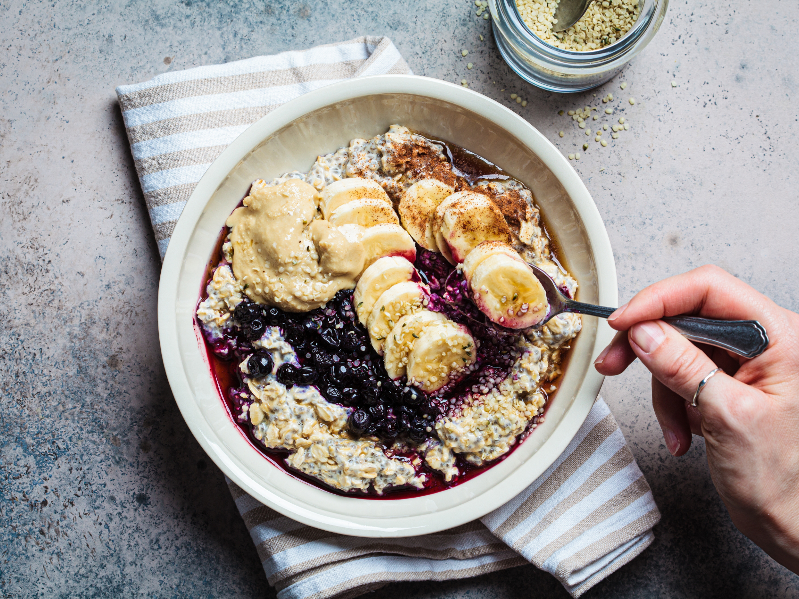 bowl of oatmeal with fruit and seeds and almond butter