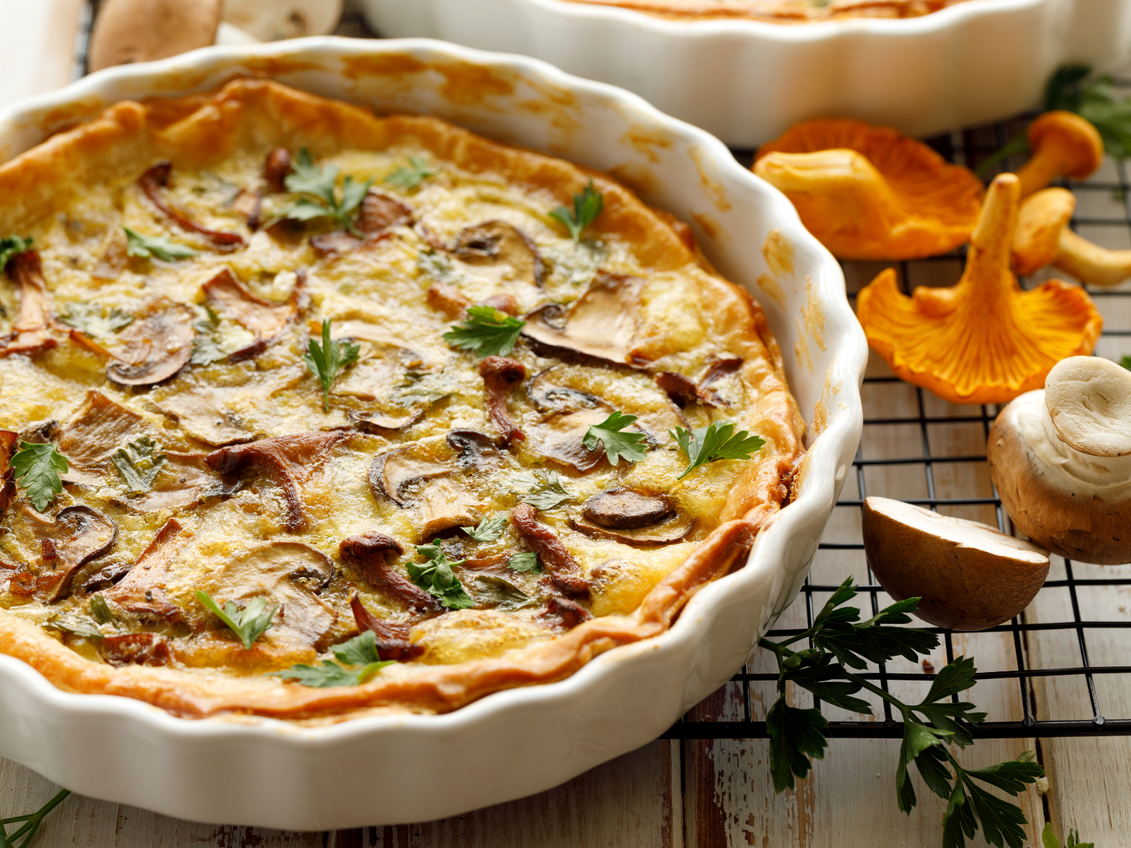 mushroom quiche in a pie dish on a cooling rack