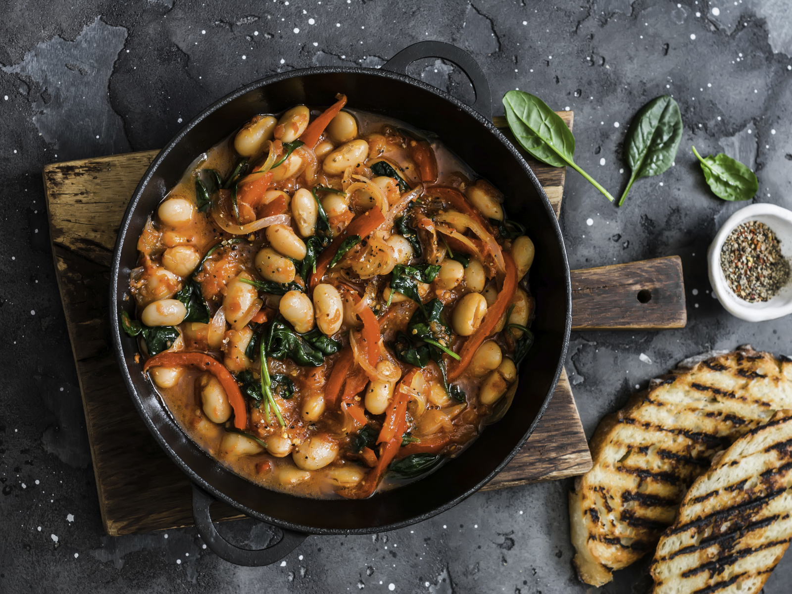 plant based bean stew with tomatoes veggies and grilled bread