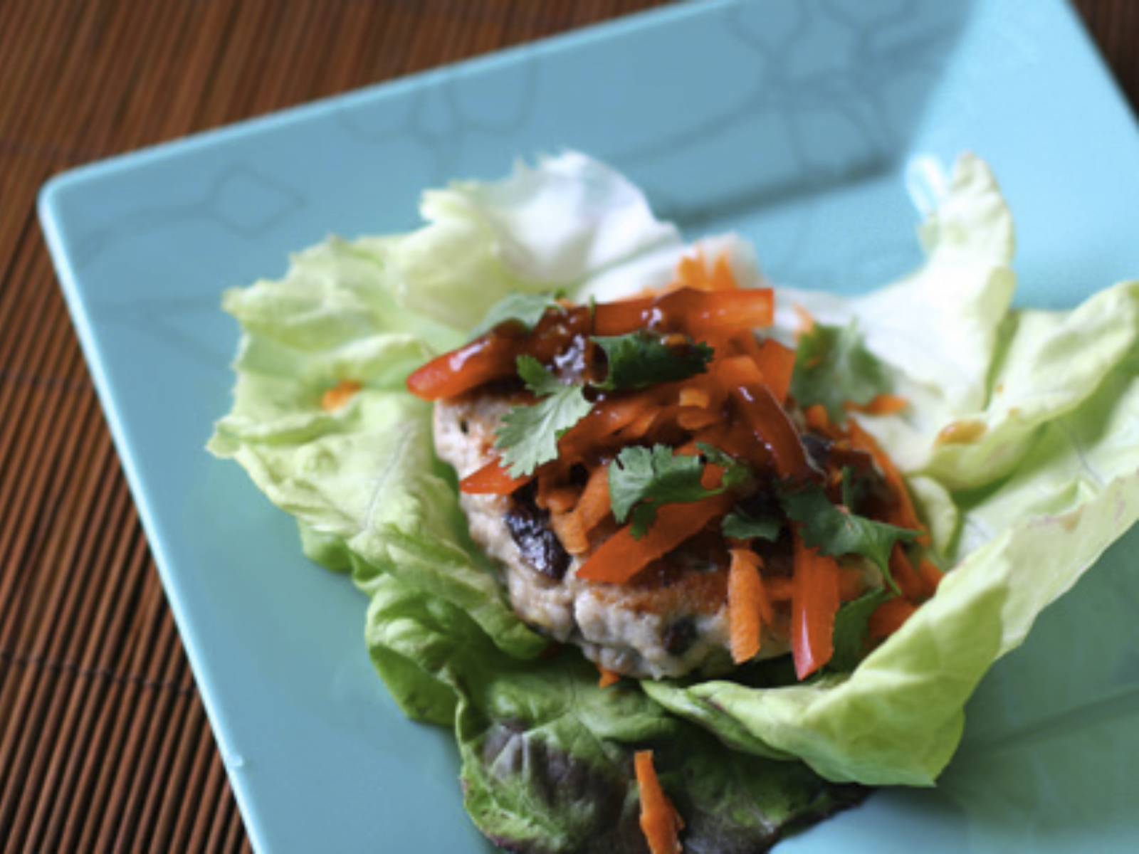 pork burger in a lettuce wrap with veggies