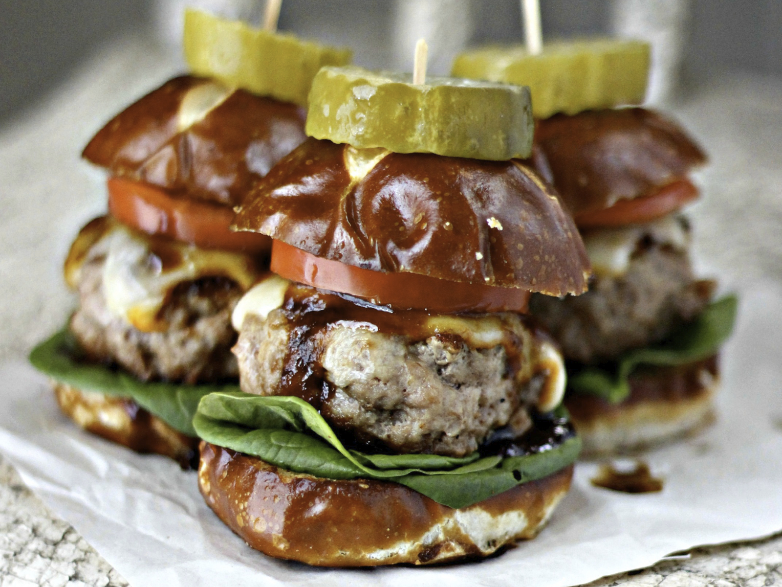 three pork burger sliders with a pickle