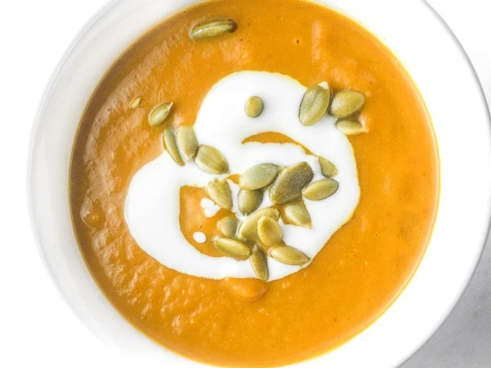 coconut pumpkin curry soup with seeds in a bowl