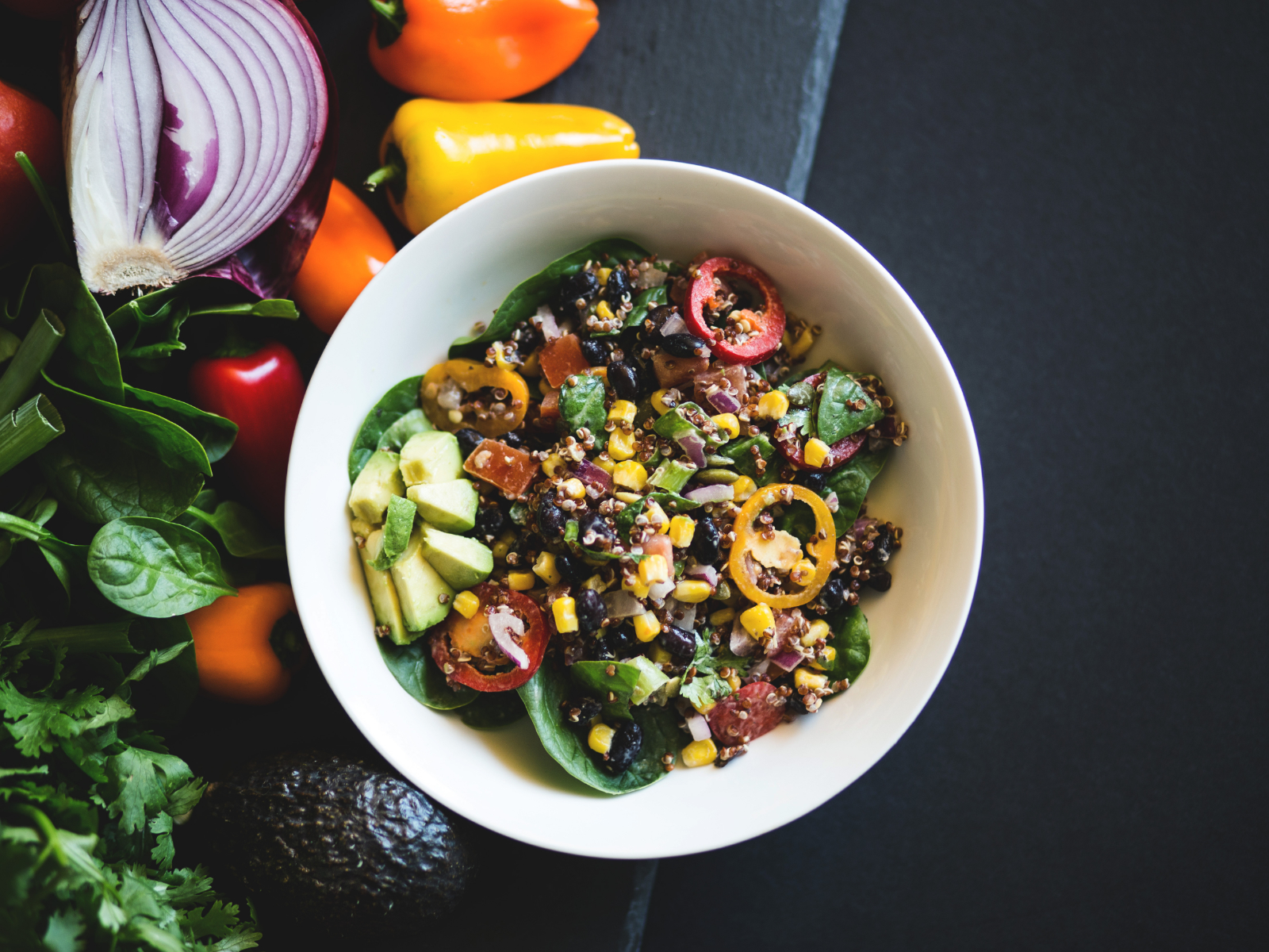 Quinoa and Black Bean Salad in a bowl with avocado and tomatoes