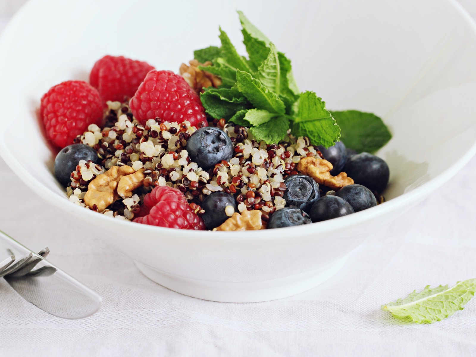 quinoa salad in a bowl with berries and walnuts