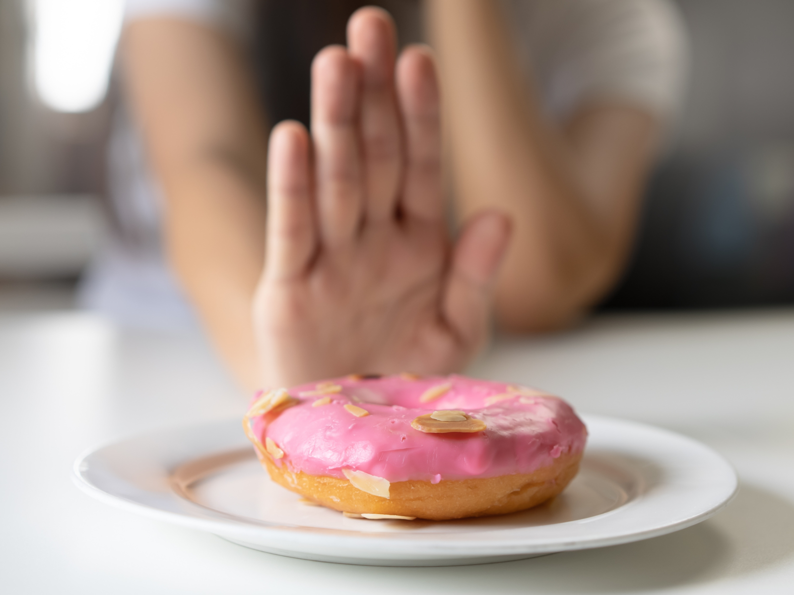 woman refusing sugary donut