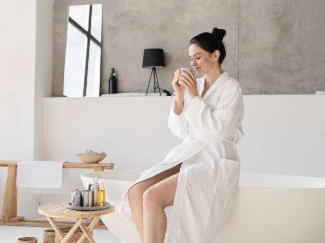 woman holding warm cup of tea before taking a bath