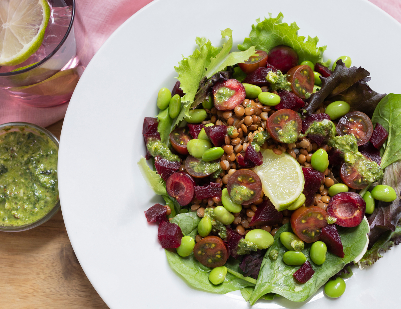 Fresh salad of lentils, edamame, beets, cherry tomatoes, green leaves and homemade pesto sauce