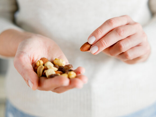 woman holding a handful of nuts to snack on