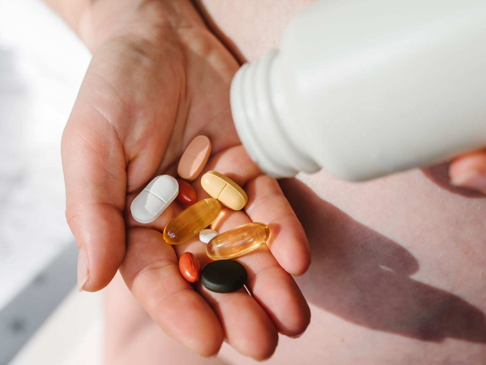woman holding a handful of supplements