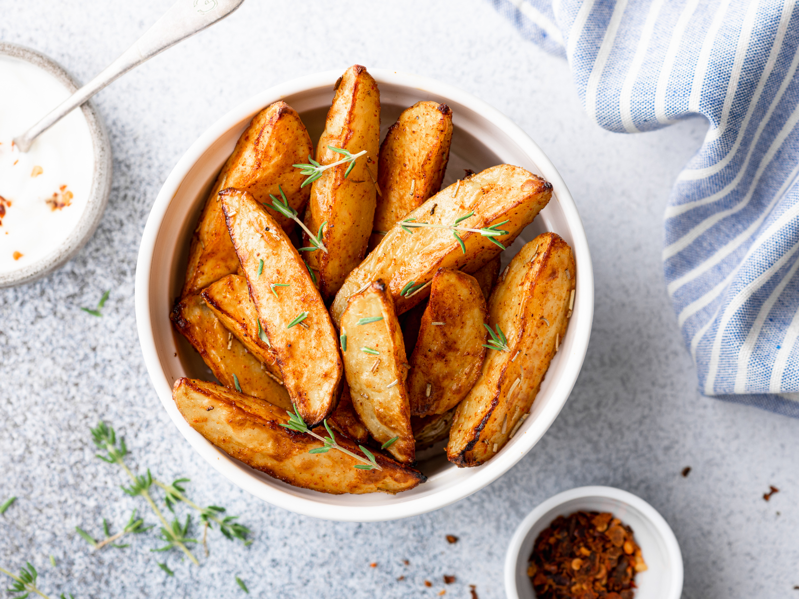 Herbs de Provence Potato Wedges in a bowl with dipping sauces