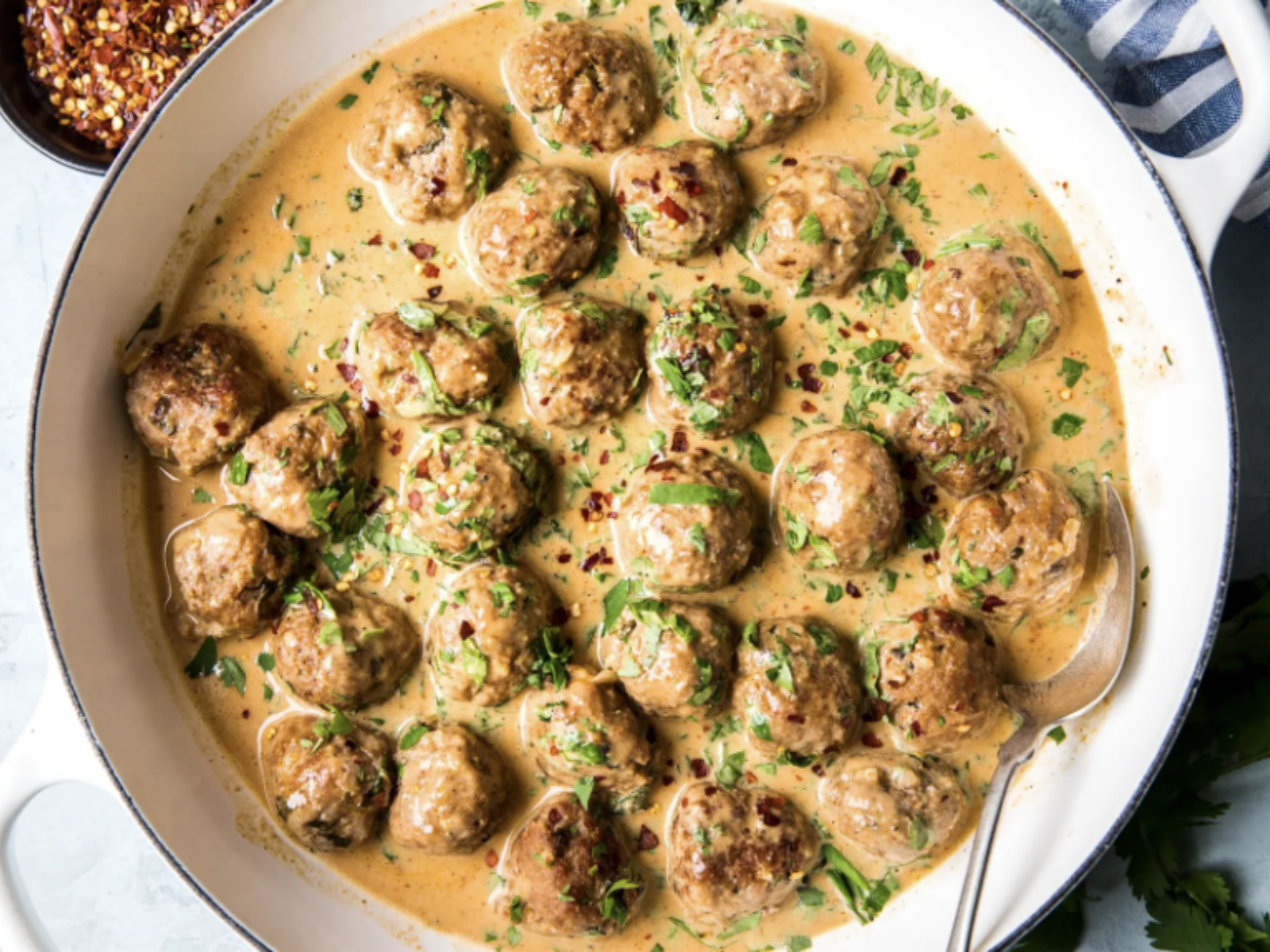 creamy curry sauce with ground turkey meatballs in a skillet