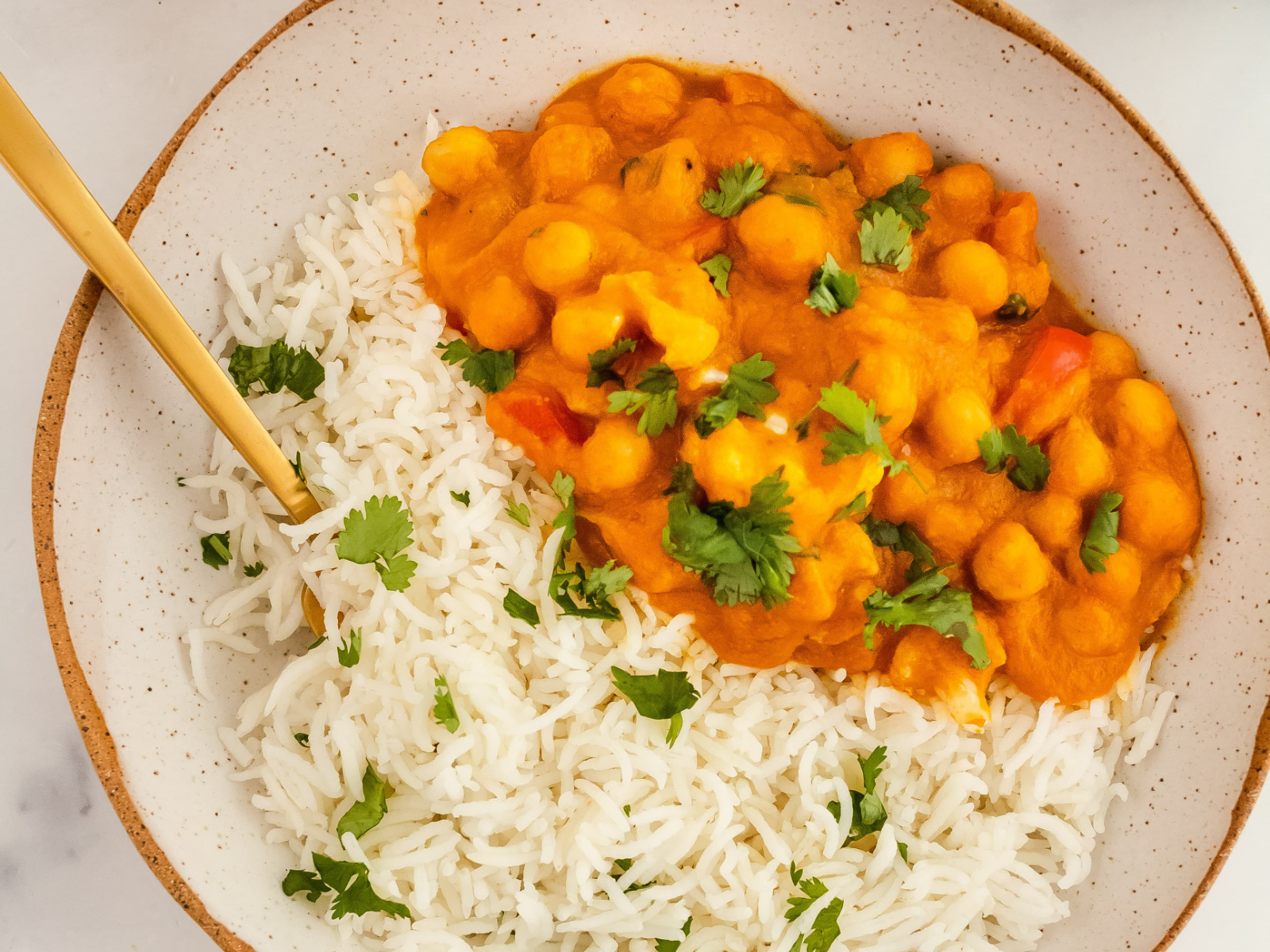vegan pumpkin curry with chickpeas and cauliflower with rice in a bowl