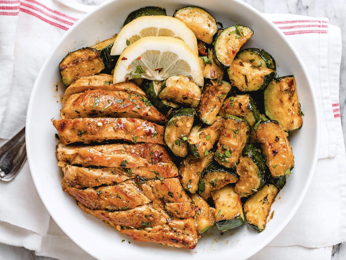 asado chicken with zucchini and lemon in a bowl